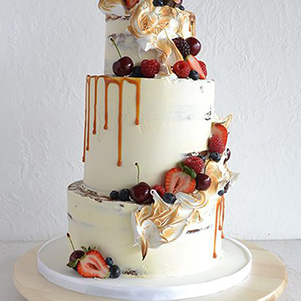 This cake is perfect for any occasion. It features 3 tiers of vanilla cake covered in vanilla buttercream and carefully placed with various berries and edible flowers. It is finished off with caramel drips along the sides.